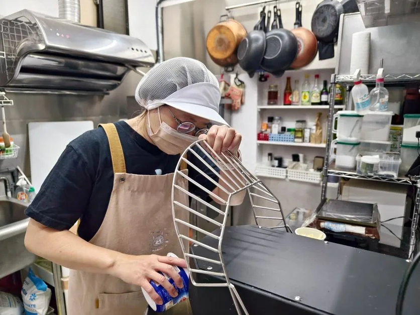 Commercial kitchen worker maintaining hood filter equipment