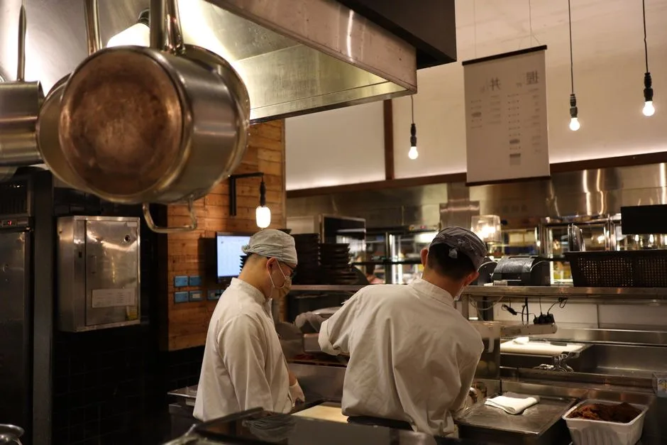 Busy commercial kitchen in Cherry Hill restaurant — grease-laden air rising above the cooking line into exhaust hood